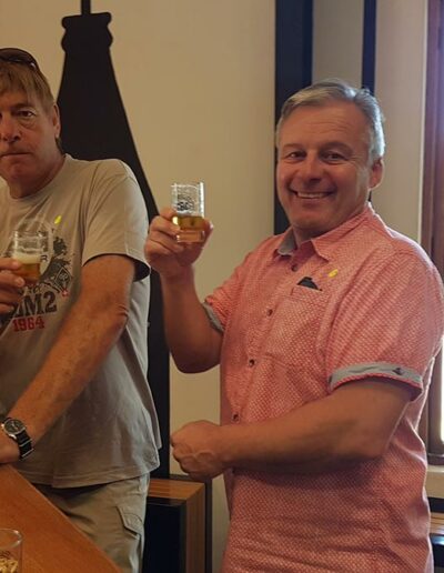 two men enjoying a beer at the bar