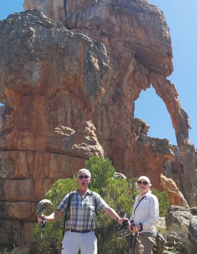 two hikers at a natural hole-in-the-wall
