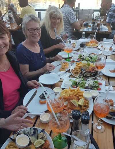 tour group enjoying fresh fish at a harbour restaurant